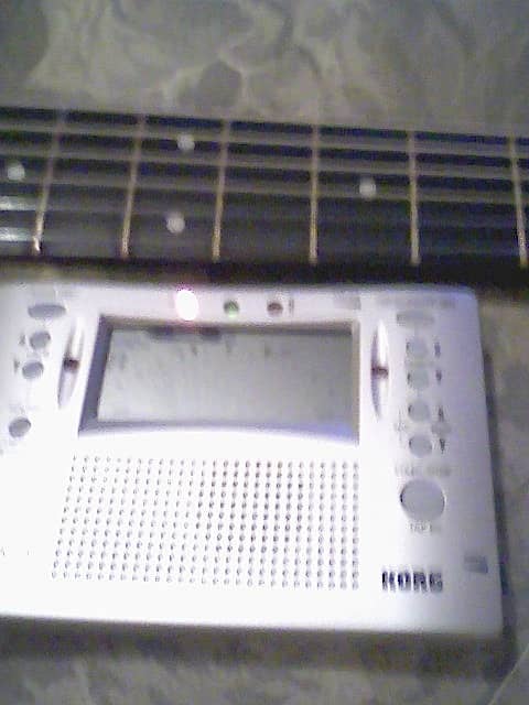 A chromatic tuner is a great help in tuning the guitar. Here, the leftmost LED is illuminated, showing that the string is flat.