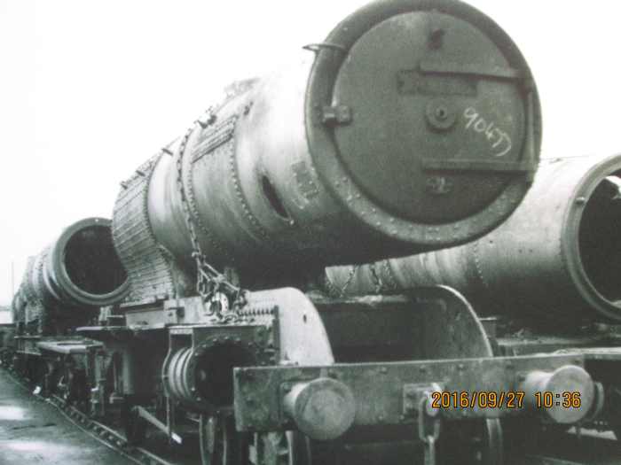 A completed boiler rests on a redundant NER Atlantic (4-4-2) locomotive frame, its cylinder housings and buffers still attached, screw coupling replaced by 3-link
