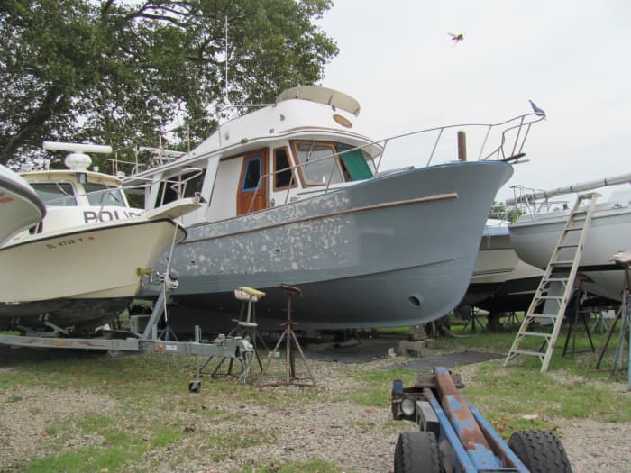 The first coat of epoxy (grey) has been applied to the entire hull (above and below the waterline). The spotty (white and grey areas) are where we have begun sanding the hull above the waterline smooth in preparation for painting.