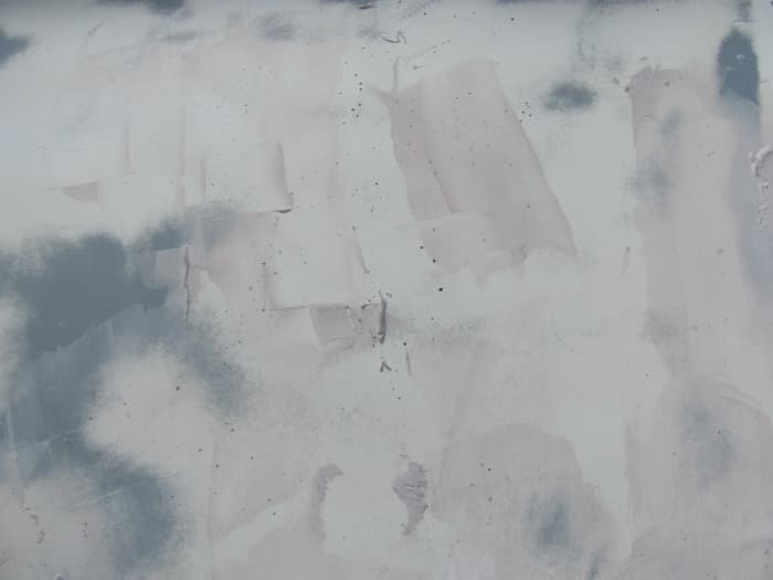 After sanding the hull (above the waterline), we could see some tiny pinholes that we missed. We applied surfacing putty and allowed it to dry before sanding.