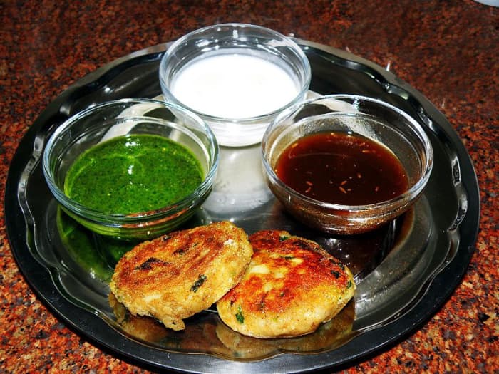 Potato cutlets served with mint chutney, tamarind chutney and yogurt.