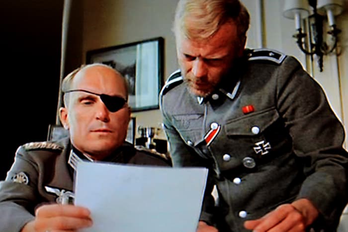Colonel Radl ( Robert Duvall) and his assistant Karl concoct a plan to kidnap or assassinate Winston Churchill. All they need now is to find the right man for the job