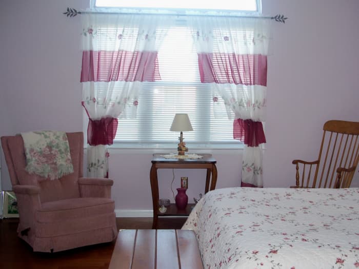 The room is large, so it easily holds a queen sized bed, a table and two chairs for lounging.