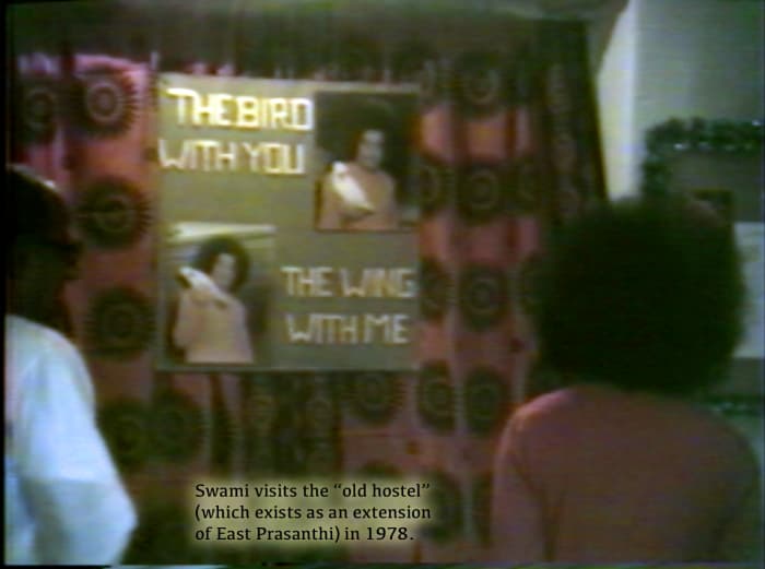 This is a rare picture of the "good old" days when Swami would visit the boys hostel very regularly. He is seeing a poster made by the boys. Swami would be with them like another among them! :)