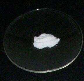 This is a watch glass, which as you can see, has a small dip in the centre. The powder in the centre is caesium fluoride.