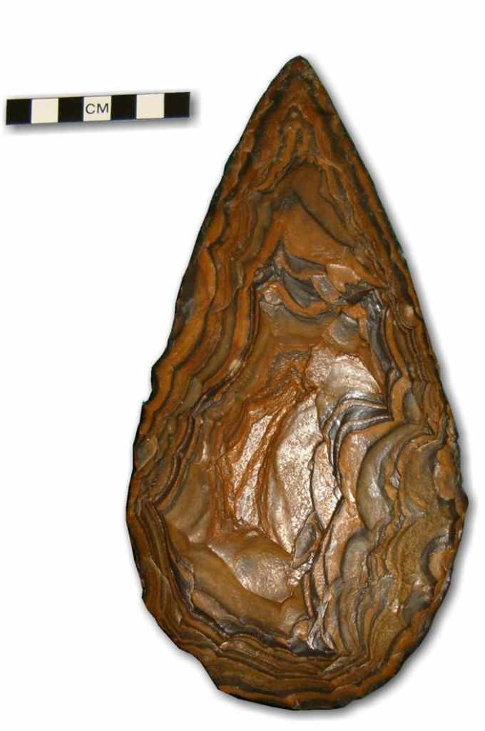 Handaxe made of banded ironstone. This Handzxe was found embedded in an exposd stratigraphic sequence in a sinkhole at Kathu Pan in the Northern Cape, South africa. The production of these artifacts (Large cutting tools, LCTs) can be seen as the exp