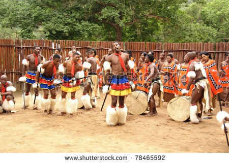 Swazi men and women in the background, in traditional clothes and performing a Swazi traditional dance