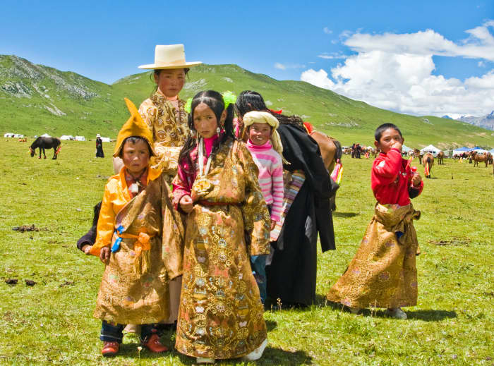 A traditional Tibetan family. Here, you can see the treeless landscape. Since there is permafrost trees and traditional burials don't thrive; further encouraging the long lived Tibetan Buddhist sky burial.