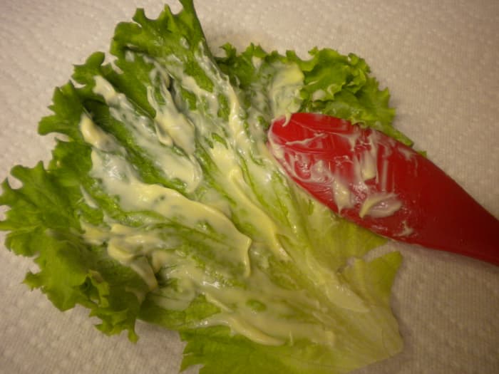 1) Gather up a large outter leaf of the green leafy lettuce (it wraps easier then romaine - doesn't break) 2. ) Apply a light coat of your favorite sandwich spread all over inside of leaf.