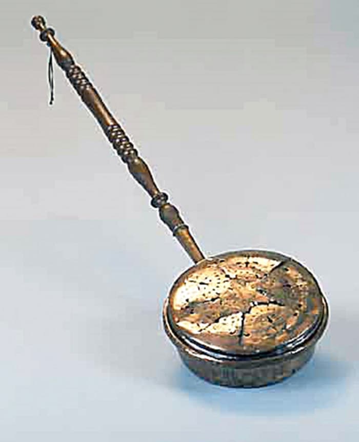 An old-fashioned bed-warmer which people used in the late 19th and early 20th century in the days before hot water bottles.
