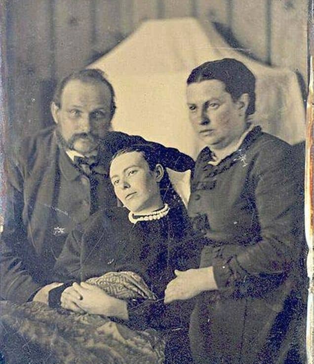 Two parents pose for their one and only family portrait with their deceased daughter, a likely victim of scarlet fever or tuberculosis.