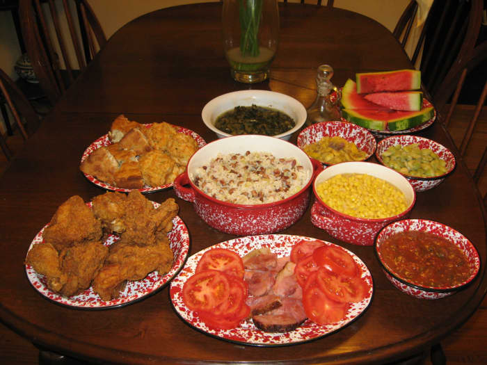A Gullah-Geechee dinner at my house. Clockwise, from top: turnip greens, pepper vinegar, squash, watermelon, lima beans, corn, okra and tomatoes, fresh tomatoes, cured ham, fried chicken, crackling bread, and biscuits. Hoppin' John is in the center.