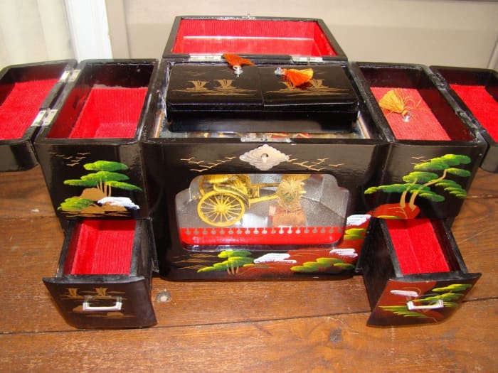 He is a beautiful vintage Japanese jewelry music box that is good large size with an oriental theme. Made of black lacquer- with a rickshaw In its glass display.