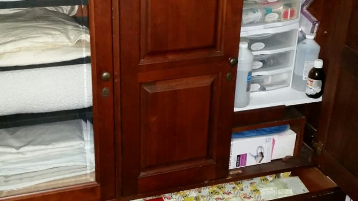 Half of this repurposed entertainment unit is a linen closet and when you open the other door, you find bathroom supplies. Clever!