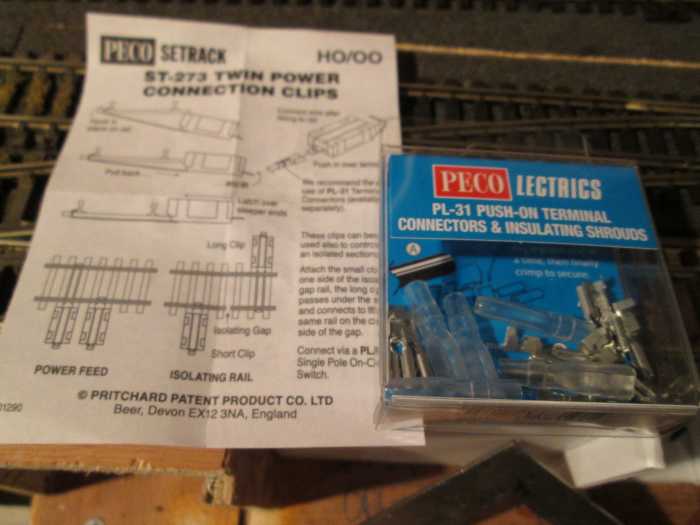 Instructions for attaching clips with a packet of connectors. Bared, twisted wires are laid onto the connector with an isolating sleeve to slide over it when the tabs have been overlapped, copper wires laid in, 'shoe-horned' onto the tab and secured