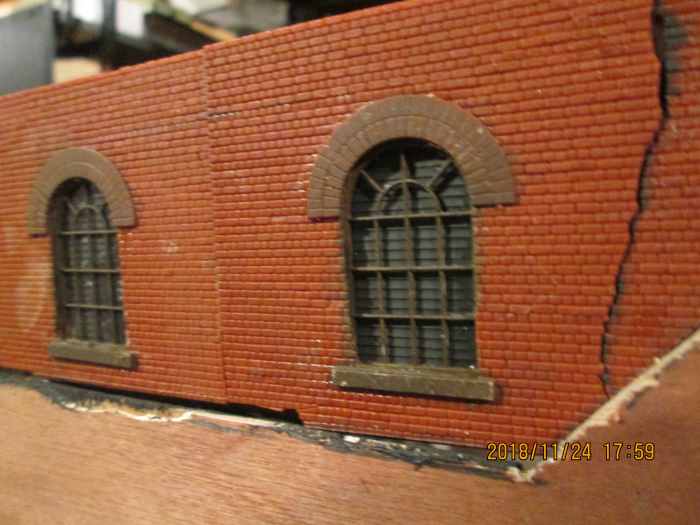 Under-line factory windows with plastic frames from a Wills' pack backed by Humbrol matt anthracite painted plastic sheet either side of the windows. Two frames backed with clear plastic 'glazing'. War damage shown by 'cracked' wall .