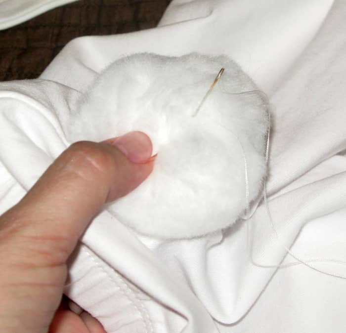 Sew the pom-pom tightly. Put the thread back in right where it came out, so it won't criss-cross and flatten the fluff.