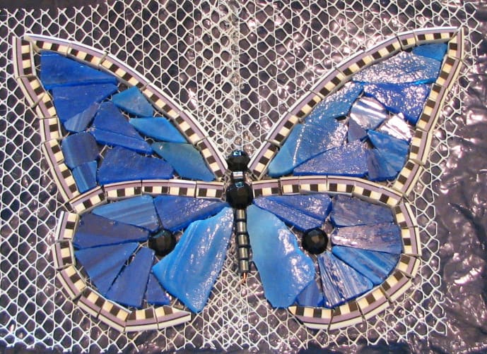 Edge is a plate rim, blue stained glass, black faceted glass beads cut in half, hematite beads. Imagine it grouted in black grout.