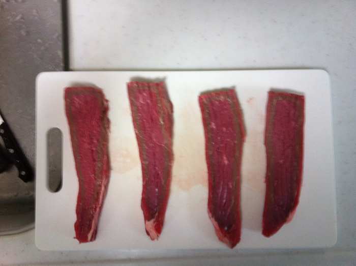 Beef strips ready to be rubbed with sour plums. Already starting to look like beef biltong.