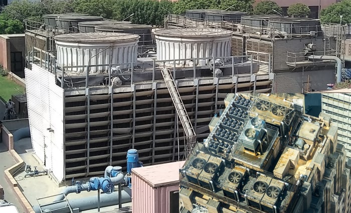 Cooling towers have reduced efficiency due to increased heat island effect, caused by proximity to ground level and lack of incident wind. Inset shows more efficient cooling towers placement on atop a high rise building.