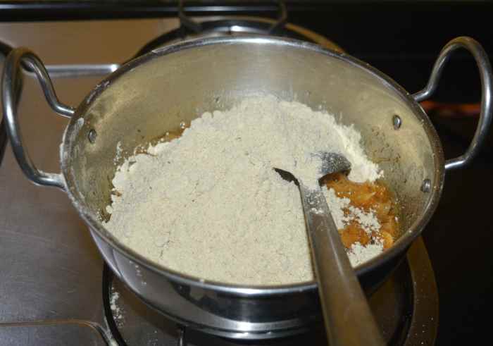 Step five: Lower the heat. Add black chana flour and mix. Add ghee and mix.