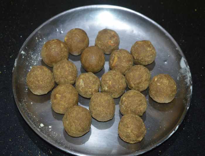 Step six: Start making balls out of this mixture when it is still hot. Take some mixture in your fist, press, and shape into a ball. Make same-sized balls. Collect them on a plate. Allow them to cool down.