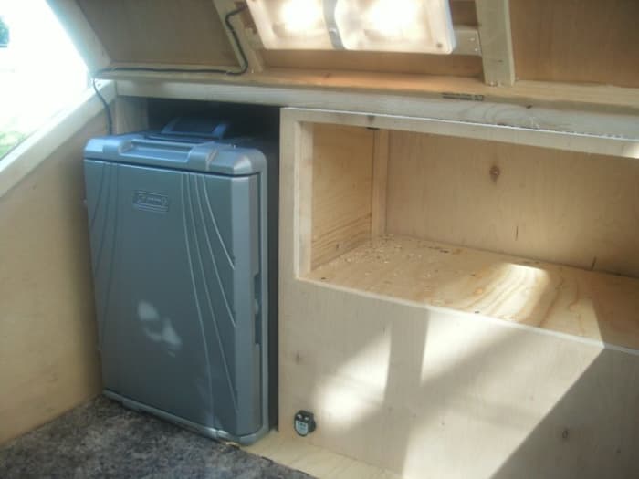 The Kitchen - Upper Cabinet opens to the kitchen, the lower cabinet opens to the sleeping area. The Fridge is a built in and the counter top is hinged for access below.