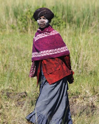 Xhosa woman wearing traditional Xhosa cloth of long skirts, embroidered with horizontal stripes and placed at varying intervals