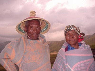 Basotho People with the Man wearing his 'grass'-made hat called Modianeo" and he and his wife waring a "Kobo"(Blanket.