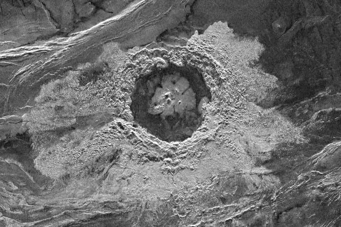 This is the Dickinson Crater in Atalanta Planita. The crater is 69 km (43 miles) in diameter. Radar-bright material surrounding the crater may be impact-ejected debris, or volcanic flows released from beneath the surface by the impact event