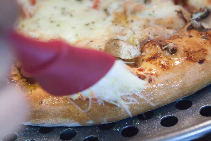 Golden Tip: As soon as the Pizza comes out of the oven, brush the edges of the fluffy pizza base with olive oil. The oil will soak into the base and make it even more delicious