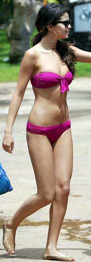 Selena Gomez walks with Justin Beiber (not in picture) flaunting her hot bikini body in Hawaii. This Selena Gomez bikini scores points for the pretty knot on tn the bikini top.