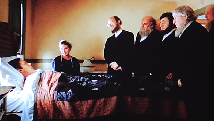 A recuperating John Book is visited by the elders of the community. The lighting in scenes such as this was inspired by the paintings of Vermeer with a single light source to one side, washing across the room and fading on the other side