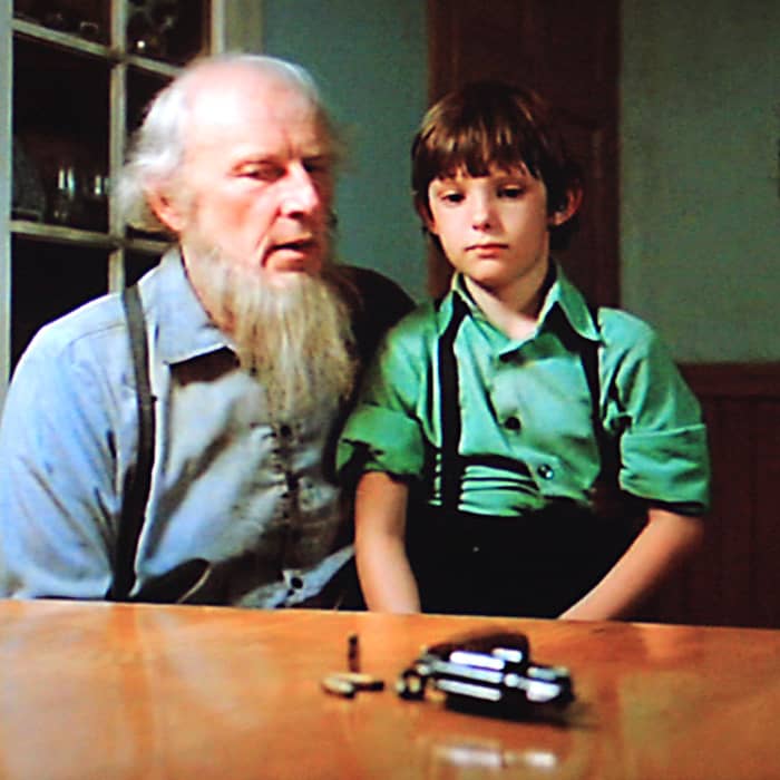Many sequences in the movie highlight the deep conflict between Amish life and John Book's life. Here, Eli Lapp lectures Samuel on the Amish abhorrence of hand guns