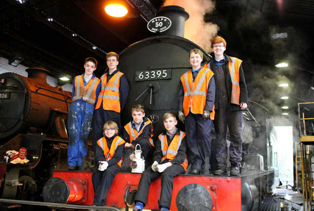 Junior Volunteers - the next generation pose by the smokebox door of 'centenarian' 63395 at Deviation Shed. These are our technicians of the future, learning the terminology and tools used in overhauling a locomotive to take it into the future.