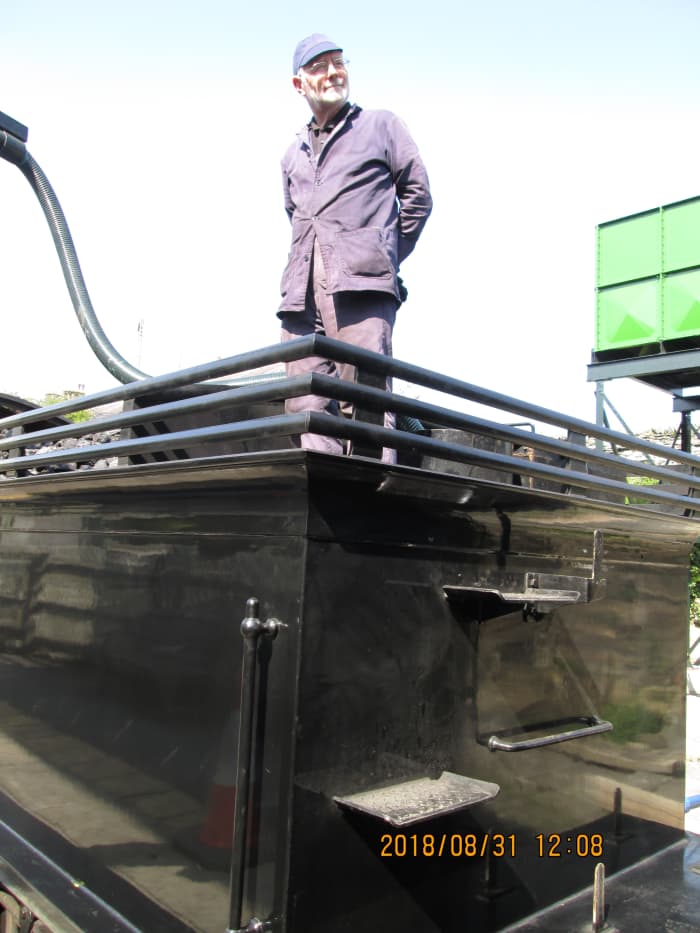 Driver Terry Newman keeps watch as the tank fills on 65894 - the water crane is fairly new, fed from a water tower on the north side of the line