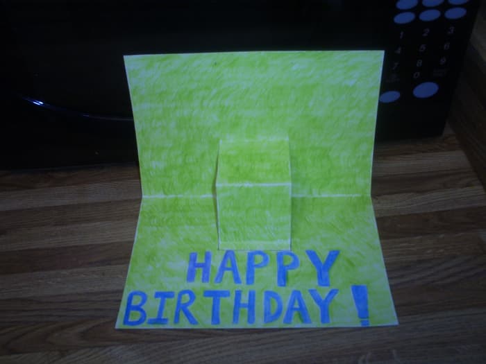 I used colored pencils to make this grassy background. Also, I sketched out Happy Birthday in pencil and colored it in with blue.