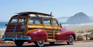 The car now best known as the woody, named in honor of its distinctive wood paneling. Shown here carrying a surf board on its roof - almost as a trophy in celebration of the surfing industry.