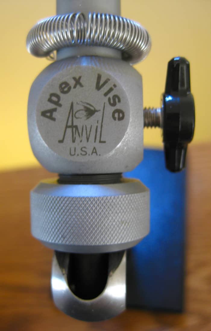 The black set screw on the right controls the head assembly rotation, while the large knurled ring at the bottom of the image adjusts the jaw gape for various sized hooks.