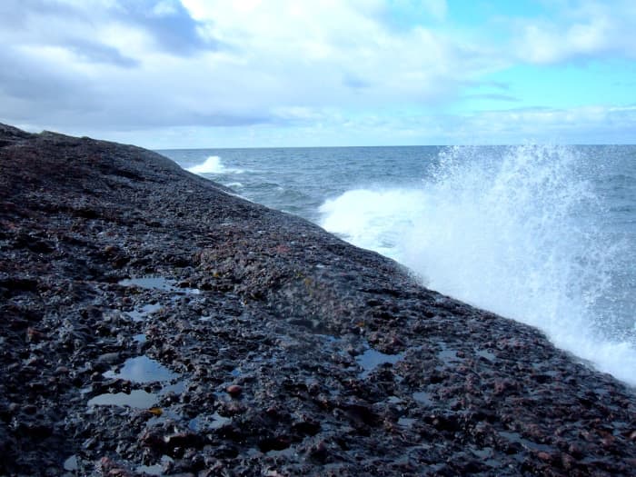 Waves of Lake Superior break on the solid rock beach at Horseshoe Bay on Michigan's Keweenaw Peninsula.