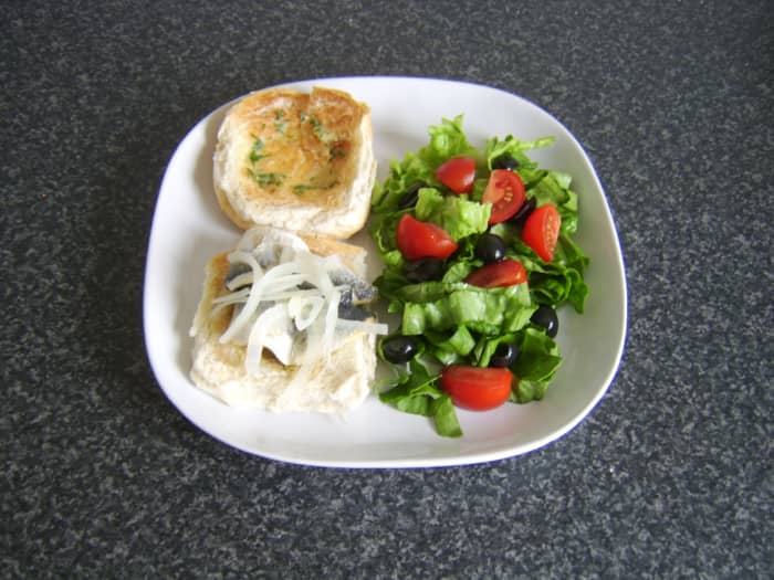 A pickled herring fillet on a herb buttered burger bun with salad makes a fairly unorthodox but delicious meal!