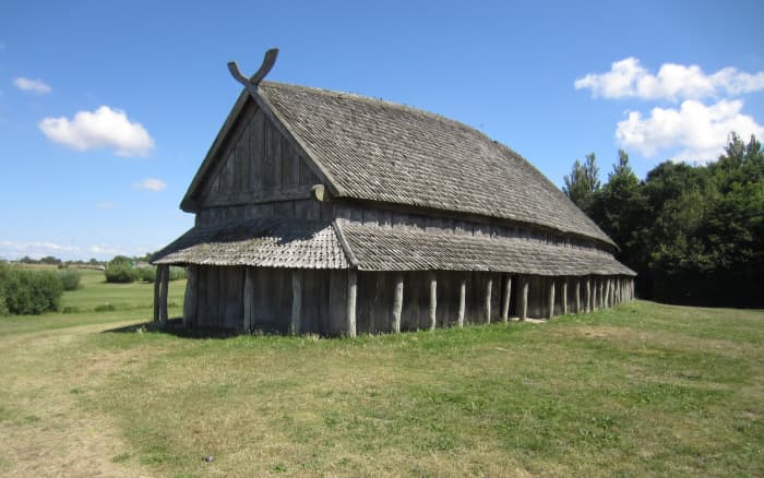 A camp longhouse with covered walkway that extends around the building to shelter various doorways