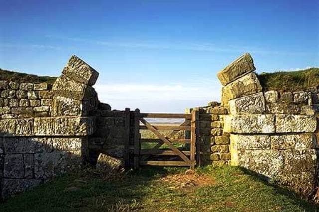 Milecastle gateway with the wall base and part of the arch put into use with a slightly more modern wooden gate
