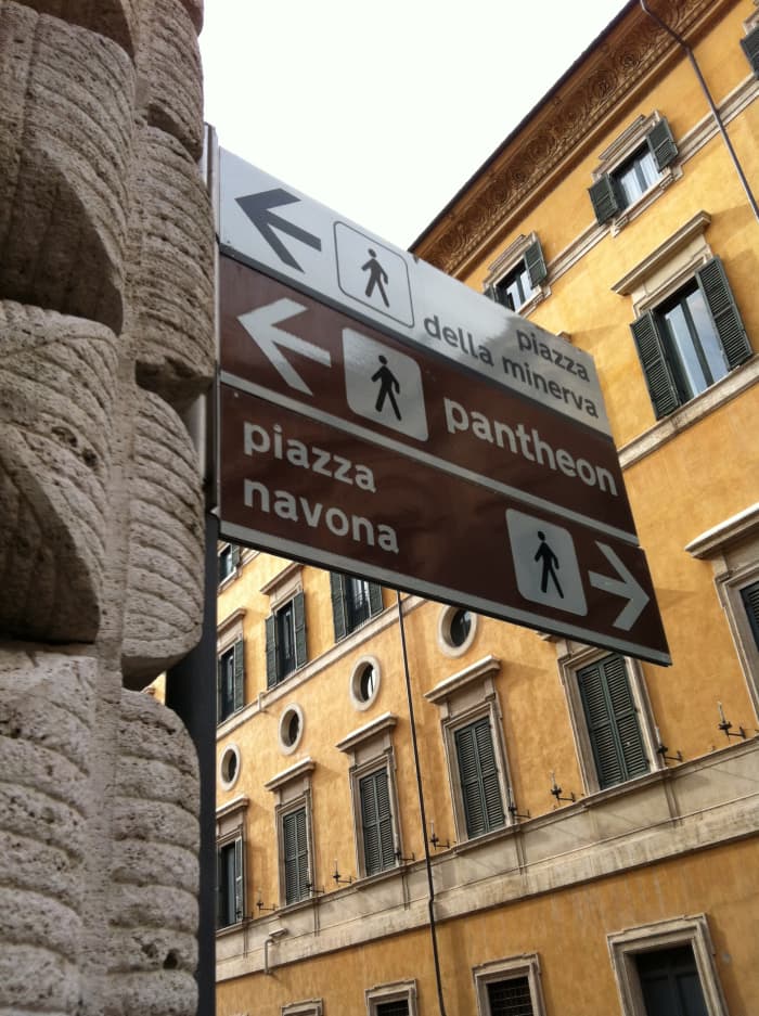 Street sign outside the church of San Luigi for Piazza Navona and the Pantheon which are within 100 meters
