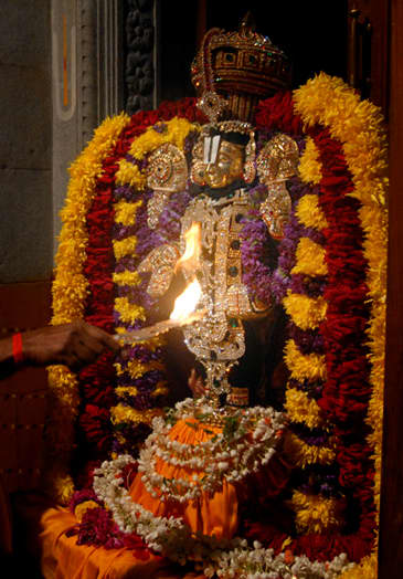 The flame lights up the the beautifully bedecked idol for all the devotees to see and experience joy.