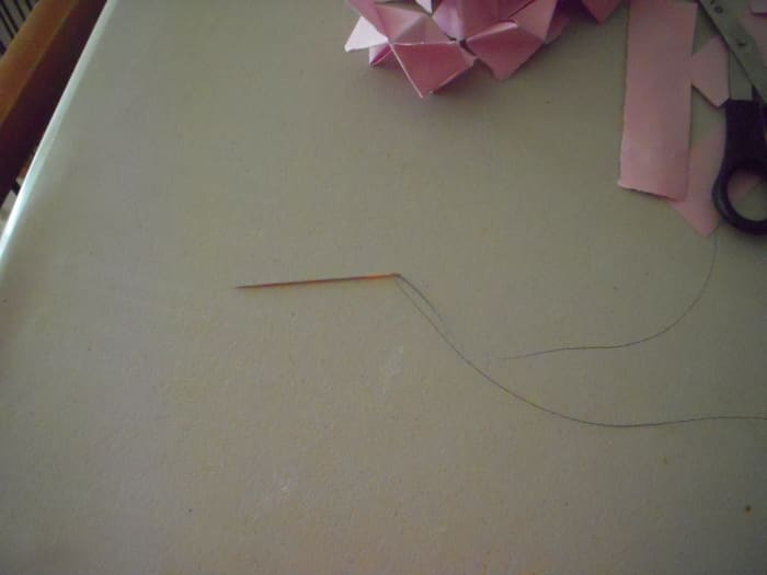 Thread doll making needle with about 42 to 60 inches of fishing line, depending on desired length of lei.