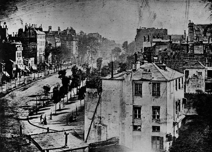 The first photograph to feature a person - a man having his shoes shined on the corner of the street This work is in the public domain in the United States, and those countries with a copyright term of life of the author plus 100 years or less..
