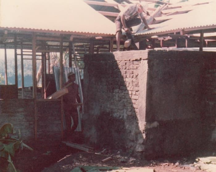 Foundation is one meter high. Columns and caps are poured concrete. The rest is concrete bricks, later plastered.