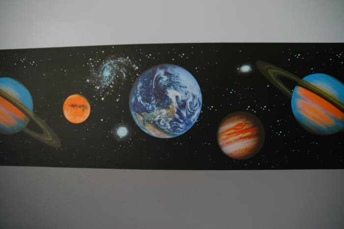 Add wallpaper border to add interest to a space-themed bedroom. Many different styles exist.