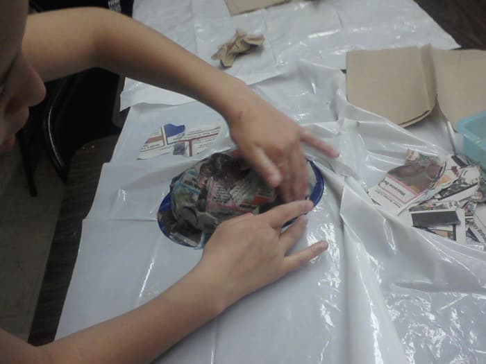 Smoothing the bumps out of the paper mache, there will probably still be some left, and that is alright